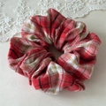 Detailopname van een rood-wit geblokte scrunchie met zachte katoenen stoftextuur - Rood Wit Geruit