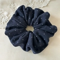Detail of navy blue knitted scrunchie with white polka dots and elegant fabric texture - Navy Blue Polka Dot