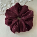 Close-up of burgundy polka dot fabric scrunchie with soft pleated texture and elastic band - Burgundy Polka Dot