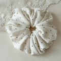 Detail showing high-elasticity cream scrunchie with black polka dots and soft fabric texture - Beige Polka Dot
