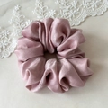 Detailed close-up of premium satin scrunchie in dusty rose with elegant folds - Pink