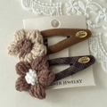 Dettaglio dei fermagli per capelli con fiori in maglia fatti a mano con tessuto di lana - Stile Fiore In Maglia Plaid