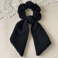 Detalle de coletero negro hecho a mano a ganchillo con lazo largo y textura de punto - Estilo de cinta de coleta / Negro
