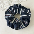 Detail van de donkerblauwe en gestreepte gebreide scrunchie met zachte ribtextuur - Marineblauw (16cm)