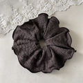 Detailed close-up of a large black ruffled scrunchie with ribbed fabric texture and piping - Dark Coffee (Contrast Edge)