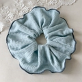 Detail of light blue pleated fabric scrunchie with dark grey overlock stitched edges - Blue (Contrast Edge)