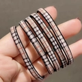 Dettaglio di elastici per capelli ad alta elasticità con motivo a quadri beige nero rosso - A quadri
