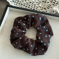 Detail view of large brown satin scrunchie with blue polka dots on a textured plate - Coffee Polka Dot Single Layer