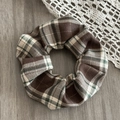 Close-up of vintage brown plaid scrunchie with thick woven texture and subtle sparkle - Coffee