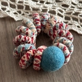 Macro view of plush wool-wrapped spiral hair tie with colorful knit textures and soft blue felt ball - Sea Salt Blue Pom Pom