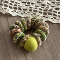 Close-up of spiral hair tie with colorful plush material and vibrant green pompom detail - Matcha Green Pom Pom