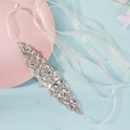 Detailed close-up of bridal sash featuring silver rhinestones and white pearls on ribbon - Silver