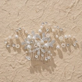 Elegant silver bridal hair comb with floral rhinestones and white pearls on beige paper - Silver