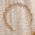 Detalle de diadema nupcial dorada con perlas, pedrería y elementos en forma de hoja - Dorado