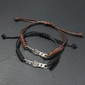 Detailansicht gewebter Ankerarmbänder in Schwarz und Braun auf Steinfläche - Anker Abzeichen (Stil 7)