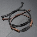 Detail handgewebter Kordelarmbänder mit mattschwarzen Metallfedern und Schiebeknoten - Schwarze Feder (Stil 6)