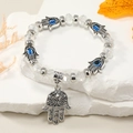 Detalle de la pulsera Mano de Fátima y Ojo Turco sobre base de piedra decorada - Blanco