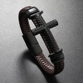 Macro shot of brown braided leather bracelet with embossed black cross and magnetic clasp - Coffee