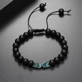 Dettaglio di bracciale con perline nere opache, accenti blu metallizzati e cordino regolabile - Nero