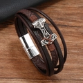 Nahaufnahme vom Wikinger-Armband mit Thors Hammer und Magnetverschluss auf Holz - Kaffeebraun