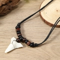 Detail of wooden beads and white shark tooth pendant on ethnic surfing necklace - Coffee Colors