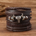 Primer plano de dije de calavera de toro plateada en pulsera multicapa de cuero marrón - Café Con Cabeza de Toro