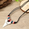 Vintage bohemian surfing necklace featuring a white shark tooth pendant and wooden beads - Red/White/Blue