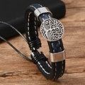 Makro-Detail des handgewebten Lederarmbands und Tree of Life Metall-Anhänger - Marineblau