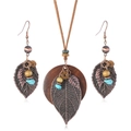 Set gioielli boho retrò con foglie di bronzo e dischi di legno su sfondo bianco - Set collana e orecchini