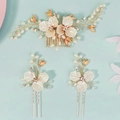 Dettaglio di acconciatura da sposa con fiori bianchi, perle e foglie dorate su sfondo blu - Set pettine per capelli (HS-J7379G) / Oro
