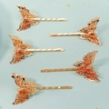 Dettaglio di cinque fermagli a farfalla dorati con filigrana e strass bianchi lucidi - Oro