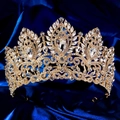 Nahaufnahme der goldenen Luxus-Tiara mit Strasssteinen auf dunkelblauem Satin - Gold Transparenter Strass (TS-J3425G)