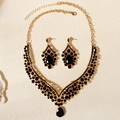 Dettaglio di un set di gioielli vintage in lega dorata con eleganti strass neri - Oro + Zircone Nero