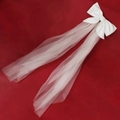Detailed view of elegant white bow hair clip with long bridal tulle veil on red background - Diagonal Bow Veil (HS-J6453)