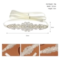 Détail de la ceinture de mariée en strass argentés avec motifs élégants sur ruban ivoire - Argenté