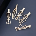 Five-piece set of gold metal hair clips with crown and heart shapes on dark blue surface - HS-J6282