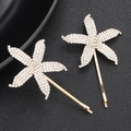 Star shaped gold hair clips set with sparkling rhinestones on black background - HS-J4000
