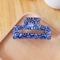 Blue rectangular hair claw clip with evil eye pattern on a light wooden tray - Dense Blue Circle Pattern (C19-4-8)