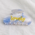Pinza per capelli in resina marmorizzata blu e bianca con scritta lovely gialla da ragazza - Lovely Blu Sfumato
