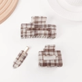 Three-piece hair clip set with brown and white plaid pattern in a minimalist home setting - Brown Plaid Collection