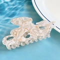 White marble resin hair claw clip with elegant gold wire accents and fluid octopus shape - White