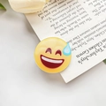 Süße gelbe Schwitzen-Emoji-Haarklammer auf offenem Buch mit weißen Tulpen dekoriert - Sprachlos