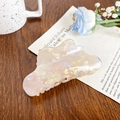 Pearlescent marble hair claw clip with iridescent finish on a rustic wooden table - Yellow Cloud