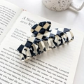 Large black and white checkerboard acetate hair claw clip on a French book background - Keel Style Claw