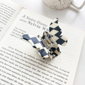Butterfly hair claw clip with black and white checkerboard pattern on a book - 3D Butterfly Claw