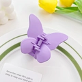 Pince à cheveux papillon violet mat élégante pour femme posée sur une assiette en céramique - Violet Crème 5.5cm