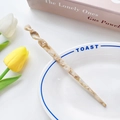 Minimalist tortoiseshell acetate hair pin with spiral design on a decorative ceramic plate - Patterned Light Brown / 17.5cm