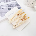Set of two cat-shaped acetate hair clips in cream and amber marble patterns - Off White