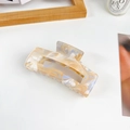 Rectangle hair claw with orange and blue marble pattern on a clean white desk - Large / Blue Multicolor