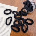 Pack of black wave texture high elastic hair ties in a clear jar on a wooden desk - Black Wave Style (E)